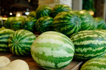 Pile of green large watermelons lying on wooden display