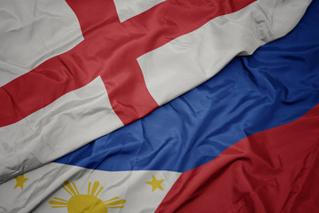 waving colorful flag of philippines and national flag of england.