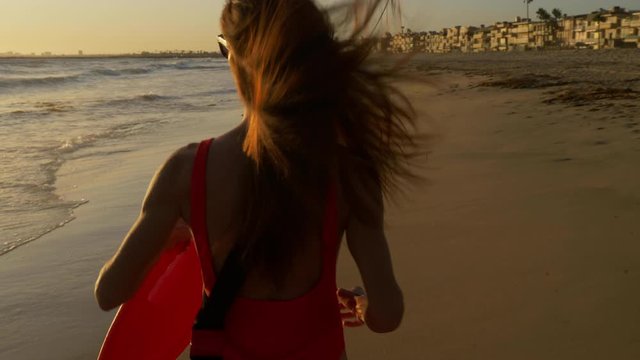 Female lifeguard running along the beach