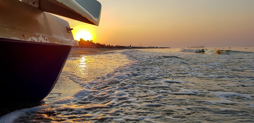 Walking catamaran against the backdrop of sunrise on the sea.