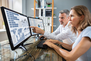 Stock Market Broker Analyzing Graphs On Laptop