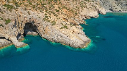 Aerial drone photo of paradise small beach of Mouros with caves and crystal clear sea, Amorgos island, Cyclades, Greece
