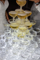 Fototapeta na wymiar Champagne filled wine glasses in the pyramid on event party banquet