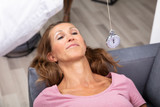 Woman Being Hypnotized With Pendulum Lying On Sofa
