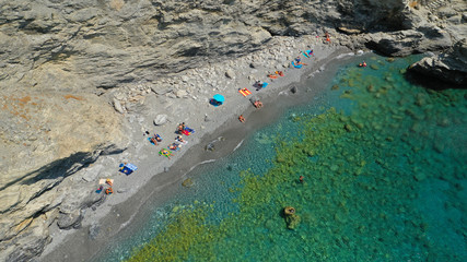 Aerial drone photo of paradise small beach of Mouros with caves and crystal clear sea, Amorgos...