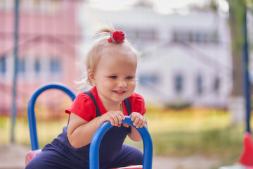 Fototapeta na wymiar little girl swinging on a swing at the playground