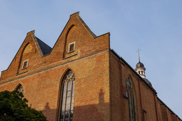Fototapeta na wymiar Low angle exterior view of old brick monastery church, Kreuzherrenkirche , on the oldest historical street, Ratinger Street, in Düsseldorf, Germany.
