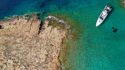 Aerial top view luxury inflatable rib speed boat docked in mediterranean emerald rocky bay with crystal clear sea