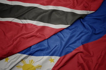 waving colorful flag of philippines and national flag of trinidad and tobago.