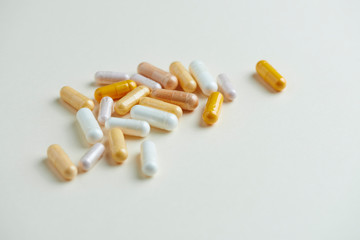 Vitamins on bright paper background. Concept for a healthy dietary supplementation. Close up. Copy space. 