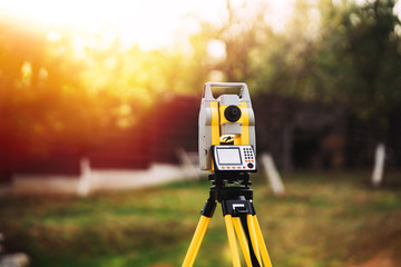 surveyor engineering equipment with theodolite and total station in a garden - obrazy, fototapety, plakaty