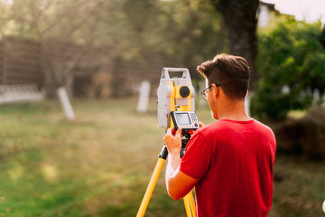 Professional surveyor engineer measuring and working with total station