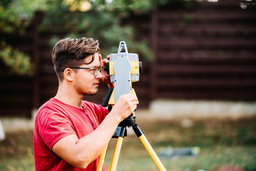 surveyor engineering working with equipment and theodolite, total station at a construction site