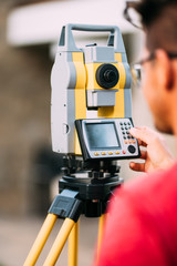 Surveyor engineer on construction site, working with total station theodolite and gps system