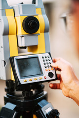 Surveyor engineer working on construction site, working with total station theodolite and gps system