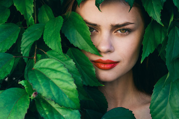 Woman with red lips green leaves