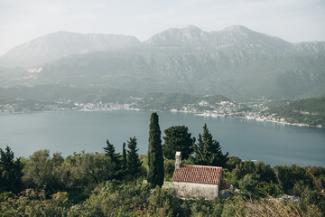 View of a secluded church among the trees by the sea in Montenegro
