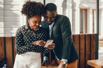 A young and stylish dark-skinned couple standing in a sunny city
