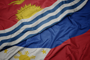 waving colorful flag of philippines and national flag of Kiribati .