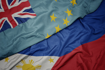 waving colorful flag of philippines and national flag of Tuvalu .