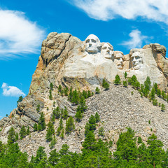 Square photograph of the carved faces of US presidents in Mount Rushmore national monument and the pine tree forest in the Black Hills, Rapid City, South Dakota, United States of America, USA.