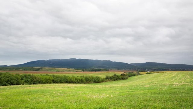Countryside landscape TIme-Lapse on the meadow with rain clouds, and the mountain Matra is in the background. Hungarian landscape view.