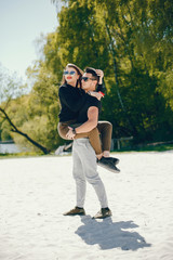 A stylish and bright love couple walks on the sunny beach