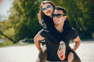 Fototapeta premium A stylish and bright love couple walks on the sunny beach