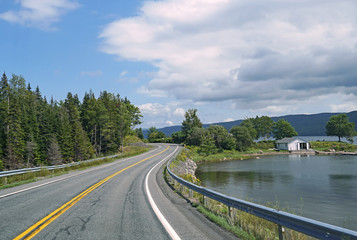 Fototapeta na wymiar Curving lakeside road, Cabot Trail, Nova Scotia, beside Bras d'Or Lake