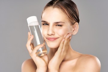 young woman applying cream on her face