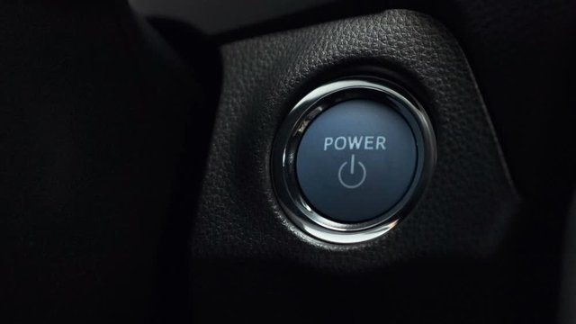 pushing blue  power ignition button to start keyless ignition hybrid car engine