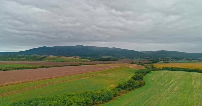 Drone view of the North Hungarian landscape of the Muzsla, part of Matra. Hills and fields of agricultural view with roads in the distance view.  Cloudy view after rain with fog in the forest.