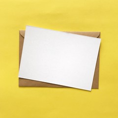 White Blank Postcard and Brown Envelope on Yellow