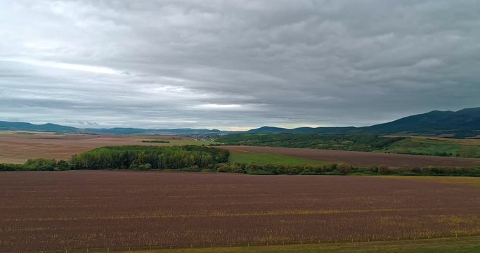 Drone view of the North Hungarian landscape of the Muzsla, part of Matra. Hills and fields of agricultural view with roads in the distance view.  Cloudy view after rain with fog in the forest.