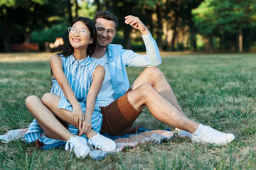 young couple doing yoga exercises in the park