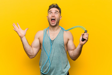 Caucasian man holding a jump rope celebrating a victory or success