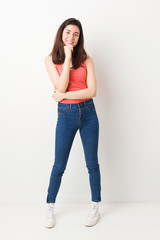 Full body young woman on white background smiling happy and confident, touching chin with hand.