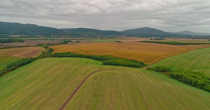 Drone view of the North Hungarian landscape of the Muzsla, part of Matra. Hills and fields of agricultural view with roads in the distance view.  Cloudy view after rain with fog in the forest.
