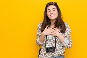 Young brunette traveler woman laughing keeping hands on heart, concept of happiness.