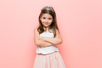 Little girl wearing a princess look who feels confident, crossing arms with determination. © Asier