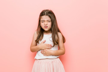 Little girl wearing a princess look sick, suffering from stomachache, painful disease concept.