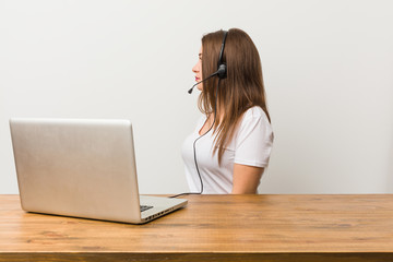 Young telemarketer woman gazing left, sideways pose.