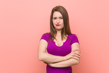 Young hispanic woman against a pink wall unhappy looking in camera with sarcastic expression.