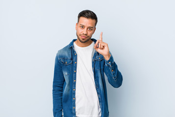 Young handsome filipino man showing number one with finger.