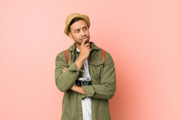 Young filipino traveler man relaxed thinking about something looking at a copy space.