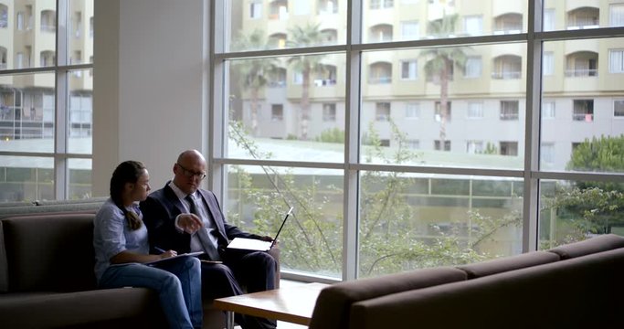 employer man and female job seeker are discussing, watching ankets and on display of laptop