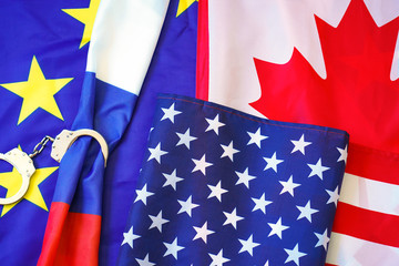 Flag of Russia in Handcuffs on the background of the European Union and Canada and United States of America flag. Sanctions against Russia, chained handcuffs, political or economic conflict.