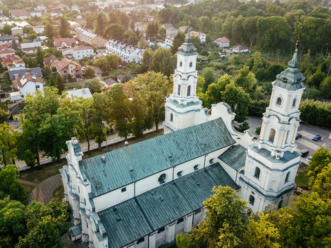 Flying under catholic church. Aerial view on the city family homes with church view near. Drone photo.