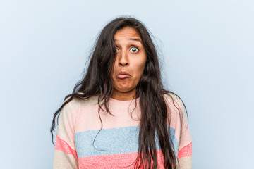 Fototapeta premium Young fashion indian woman shrugs shoulders and open eyes confused.