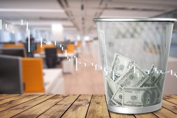 Money in thash bin on wooden floor